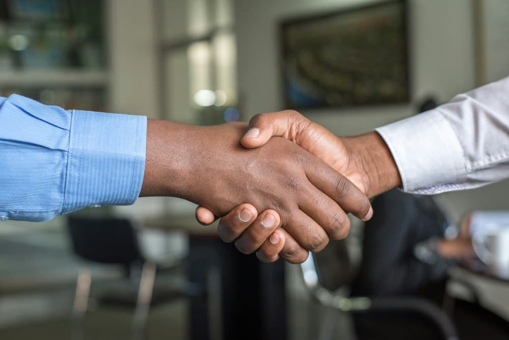 Two people shaking hands to close a deal